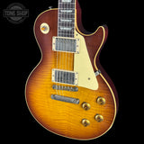 Electric guitar with a sunburst finish on a black background, featuring the Tone Shop logo.
