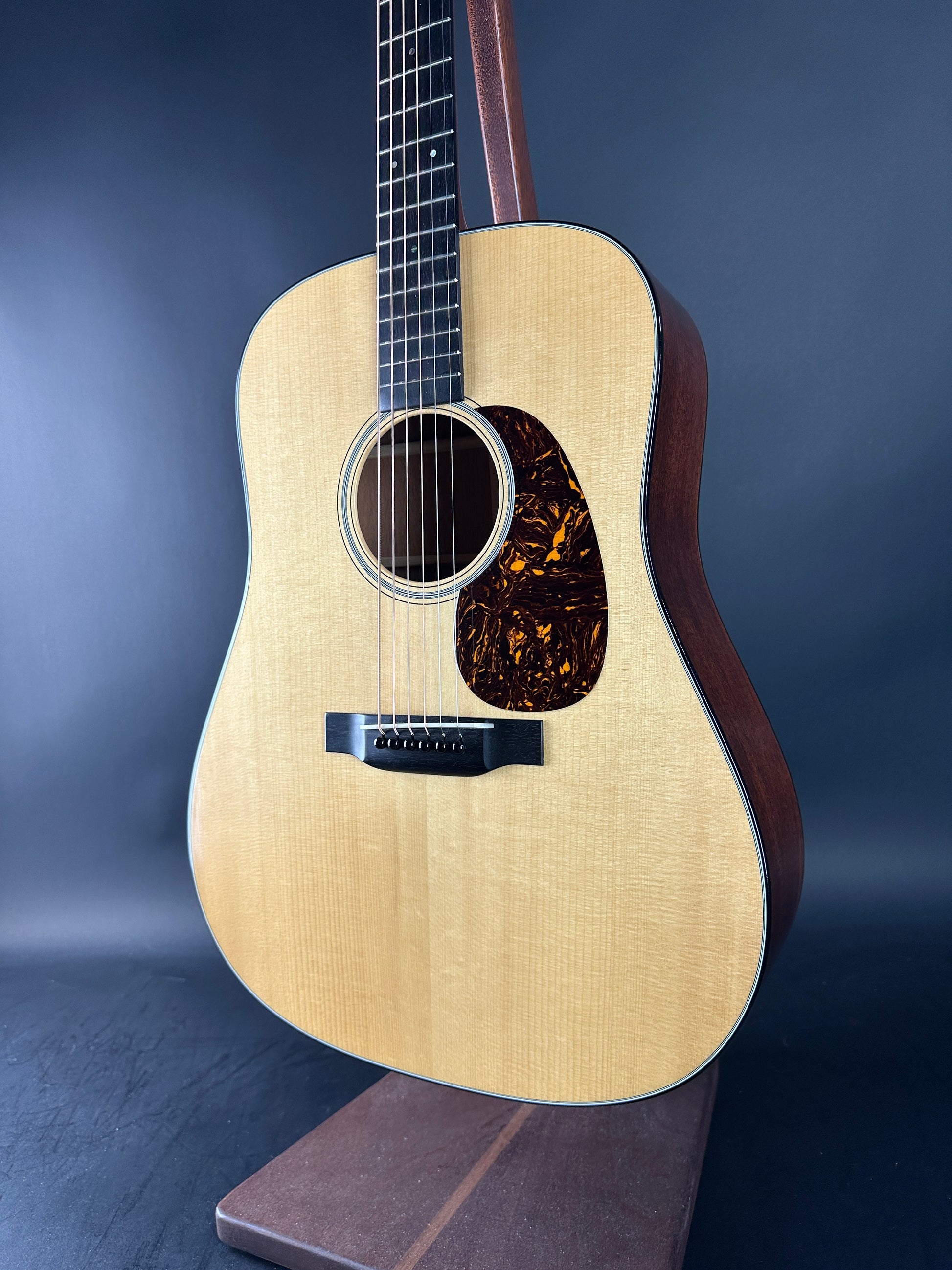 Acoustic guitar with a dark brown finish on a blue background