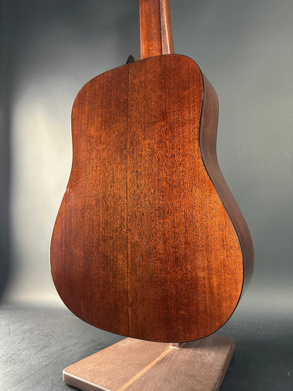 Close-up of a wooden acoustic guitar body on a gray background