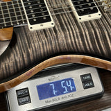 PRS Custom 24 Birds of a Feather Limited Charcoal Microburst on scale displaying weight.
