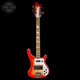 Red electric bass guitar with a white pickguard on a black background, featuring the Tone Shop logo.