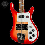 Red electric bass guitar with a white pickguard on a black background, featuring the Tone Shop logo.