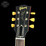 Gibson Les Paul guitar headstock with yellow tuning pegs on a black background