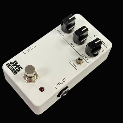 Guitar effects pedal with knobs and switches on a textured surface