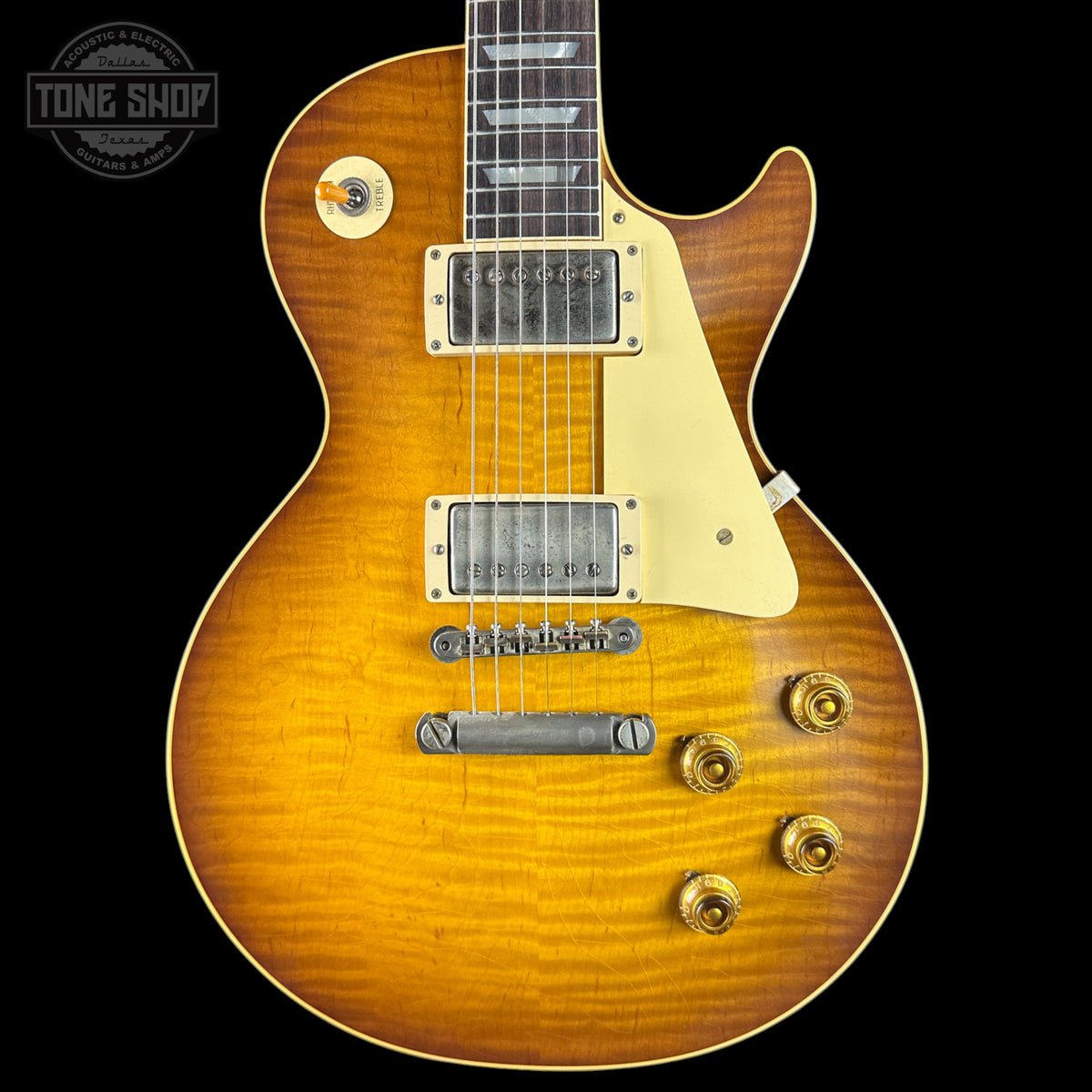 Electric guitar with a sunburst finish on a black background, featuring the Tone Shop logo.