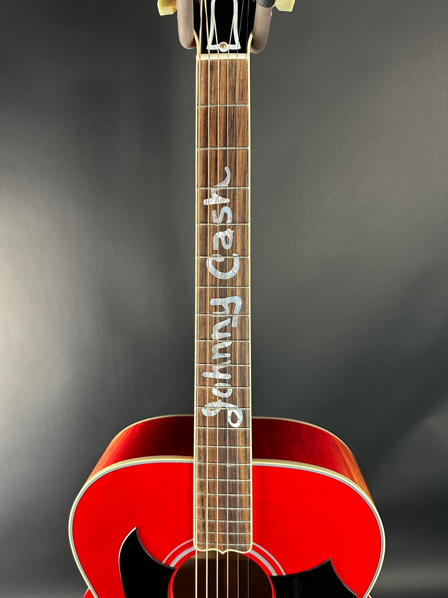 Red acoustic guitar with 'Case Guitar' branding on a dark background