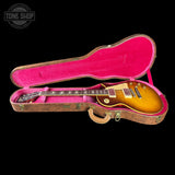 Electric guitar in a pink case with 'Tone Shop' logo in the corner.