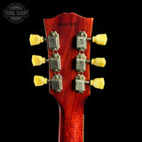 Close-up of a red guitar headstock with tuning pegs on a black background, featuring 'Tone Shop' branding.