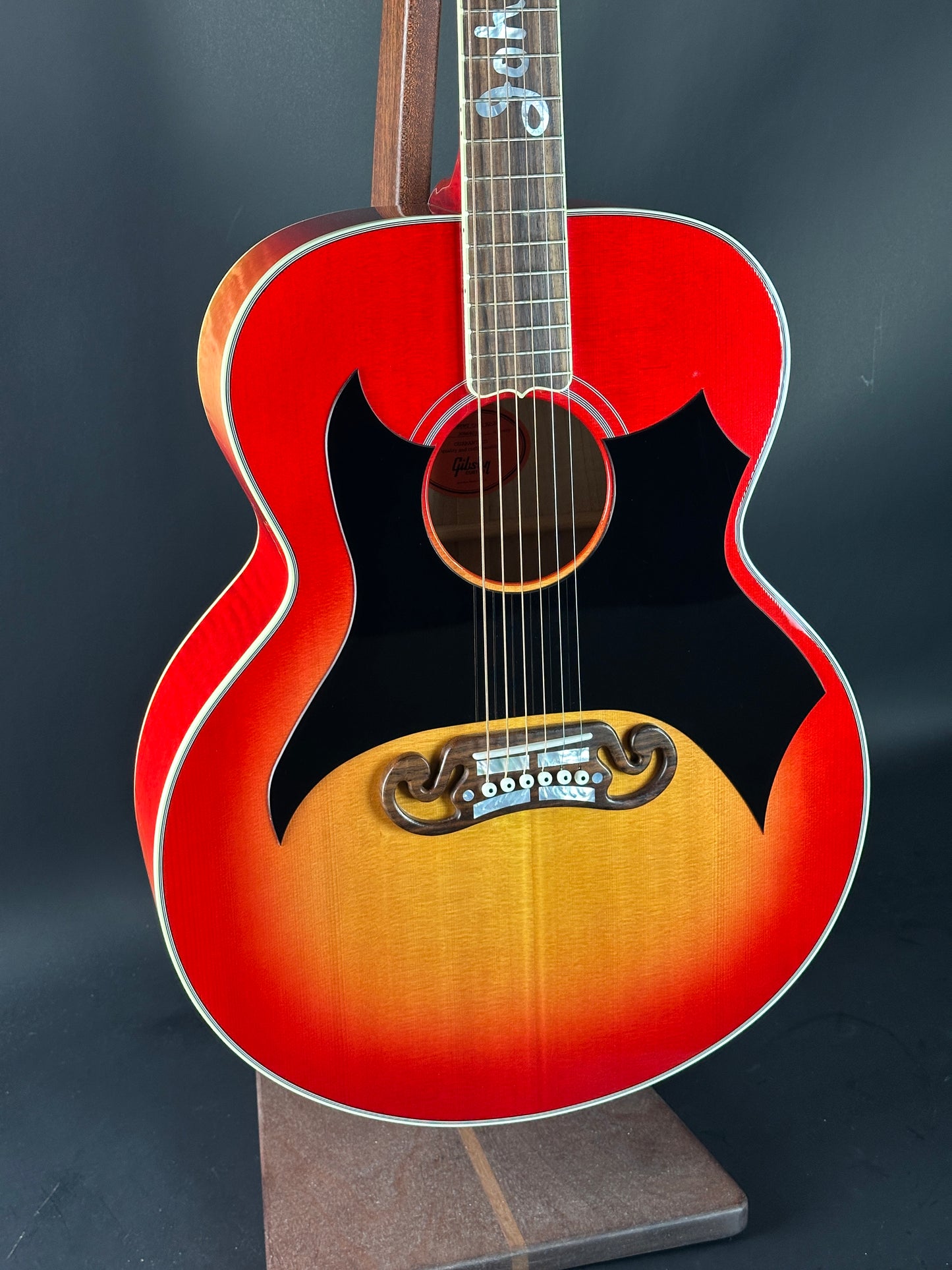 Red and black acoustic guitar on a dark background