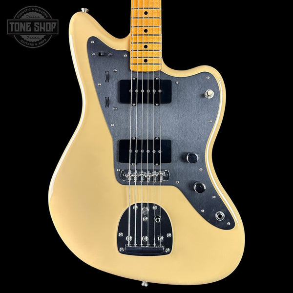 Electric guitar with a blonde finish and black pickguard on a white background, featuring the Tone Shop logo.