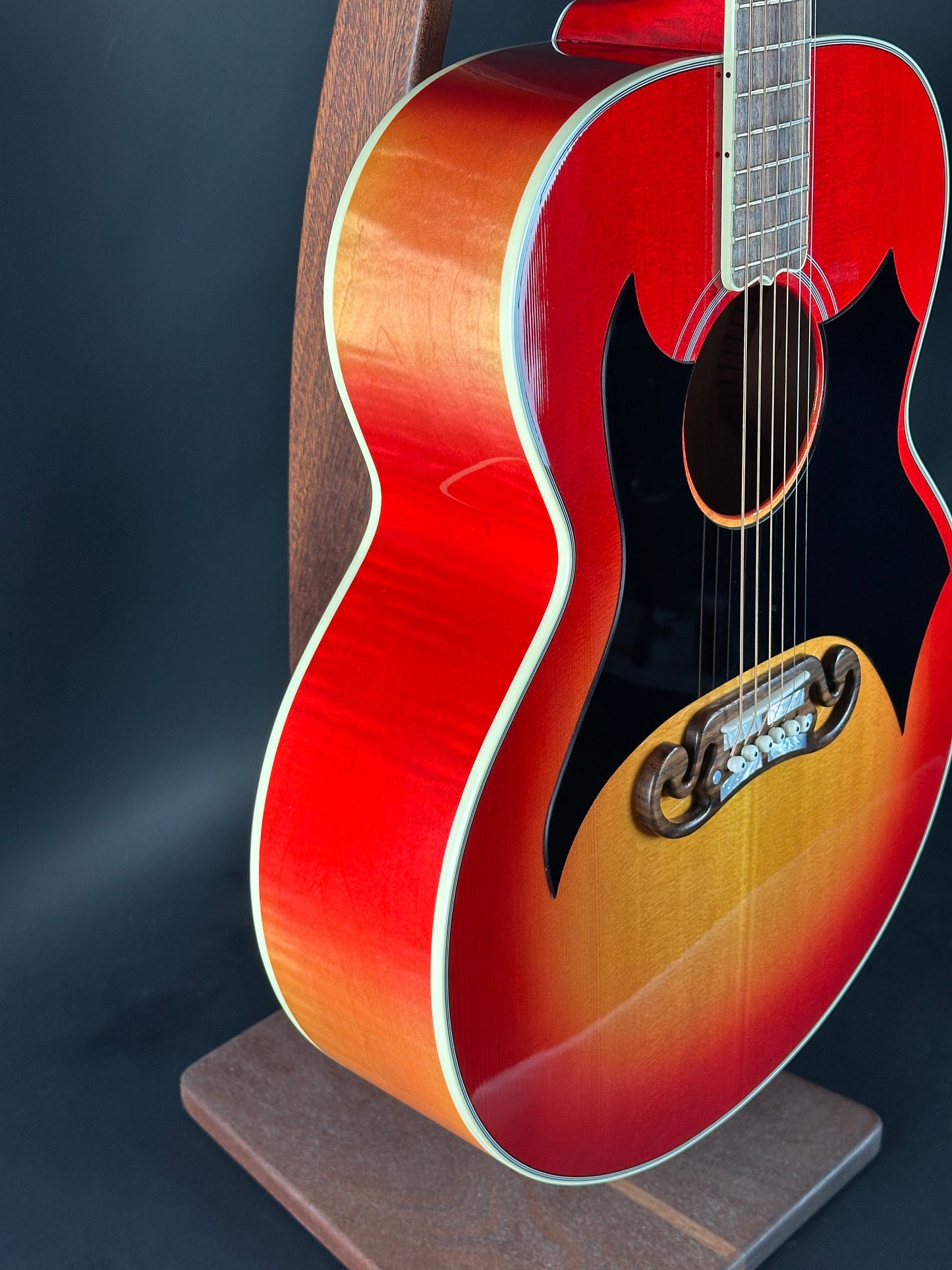 Acoustic guitar with a red and brown finish on a dark background