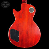 Red electric guitar body with a visible brand logo on a black background