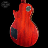 Red electric guitar body with a visible brand logo on a black background
