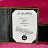 Gibson Custom Certificate of Authenticity on a guitar case with a pink background