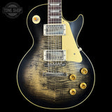 Electric guitar with a worn finish on a black background, featuring the Tone Shop logo.