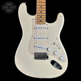 Cream-colored electric guitar with a maple neck, featuring three single-coil pickups, a black bridge, and white control knobs, shown against a black background with a Tone Shop watermark.