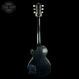 Black electric guitar on a white background with 'Tone Shop' logo.