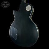 Black electric guitar body with 'Tone Shop' logo in the corner