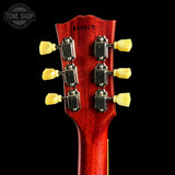 Close-up of a red guitar headstock with tuning pegs on a black background, featuring 'Tone Shop' logo.