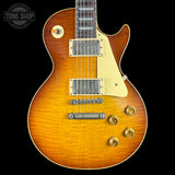 Electric guitar with a sunburst finish on a black background, featuring the Tone Shop logo.