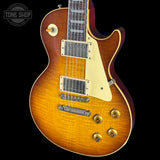 Electric guitar with a sunburst finish on a black background, featuring the Tone Shop logo.