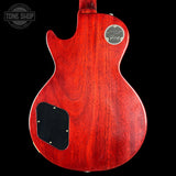 Red Gibson guitar body with a visible brand logo on a black background
