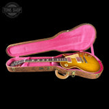 Electric guitar in a pink case with 'Tone Shop' logo in the corner.