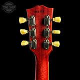 Close-up of a red guitar headstock with tuning pegs on a black background, featuring 'Tone Shop' branding.