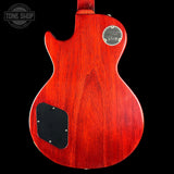Back view of a red electric guitar with a Gibson logo on a black background