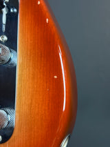 Close-up of a guitar's wooden neck and headstock against a dark background