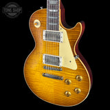 Glossy electric guitar with a sunburst finish on a black background, featuring 'Tone Shop' branding.