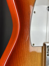 Close-up of a guitar's wooden body with a metal pickguard.
