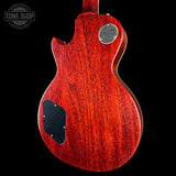 Red electric guitar body with a visible brand logo on a black background