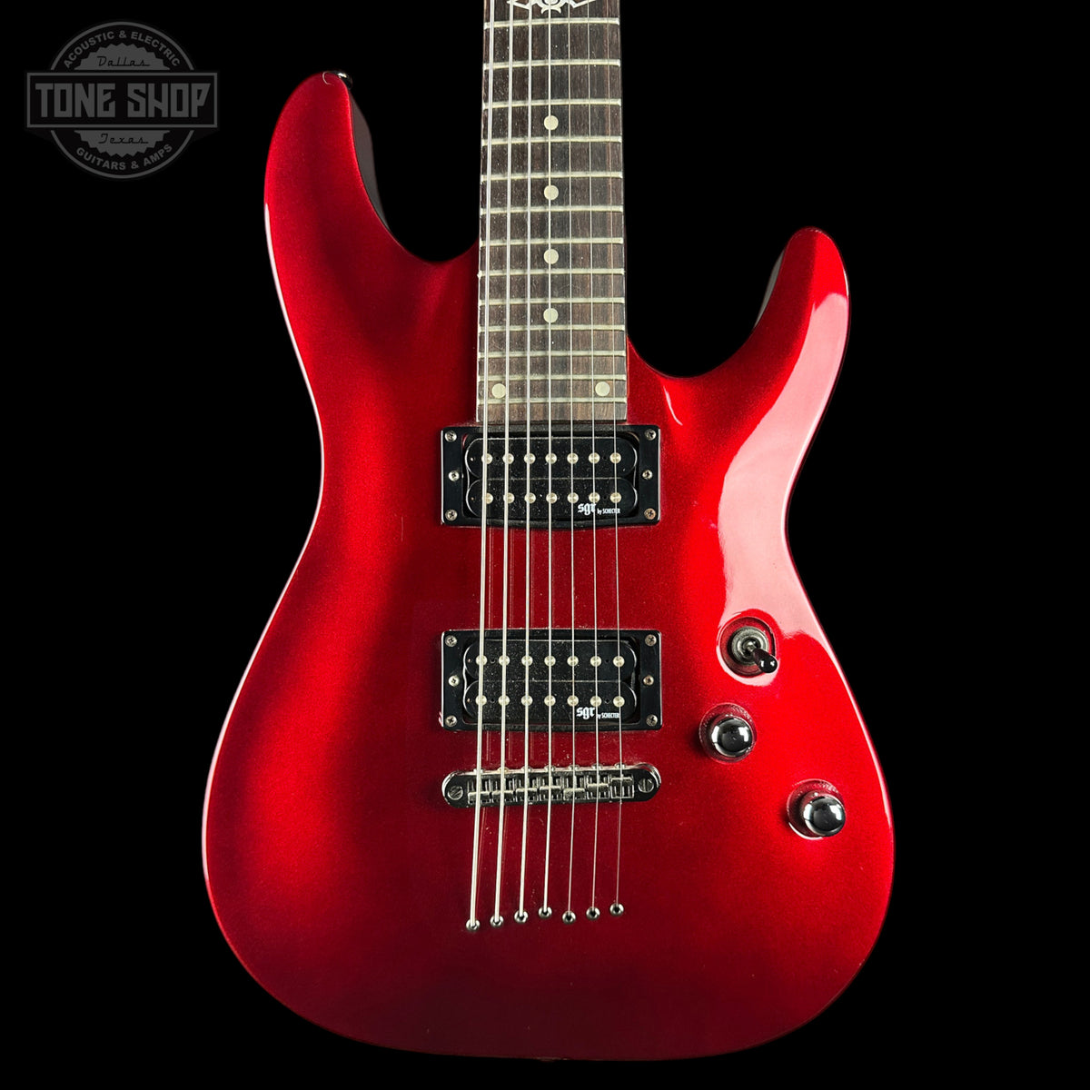 A red electric guitar with a glossy red finish, black pickups, and a dark fretboard, shown against a black background with a Tone Shop logo in the top left corner.