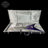 Purple electric guitar in a hard-shell case with 'Tone Shop' logo.