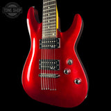 A red electric guitar with a glossy finish, featuring black pickups, chrome hardware, and a dark fretboard, shown against a solid black background with a Tone Shop watermark in the top left corner.