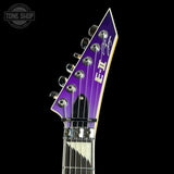Close-up of a guitar headstock with 'ET' branding on a black background