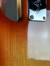 Close-up of a guitar's brand logo on a wooden surface
