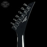 Close-up of a guitar's headstock with tuning pegs on a black background, featuring the 'Tone Shop' logo.