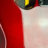 Close-up of a glossy red electric guitar body with a visible screw defect on the upper bout area.