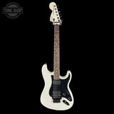 White electric guitar on a black background with 'Tone Shop' logo.
