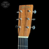 Close-up of the headstock of a Martin & Co. acoustic guitar, showing the six tuning pegs, six strings, and the brand name 'Martin & Co.
