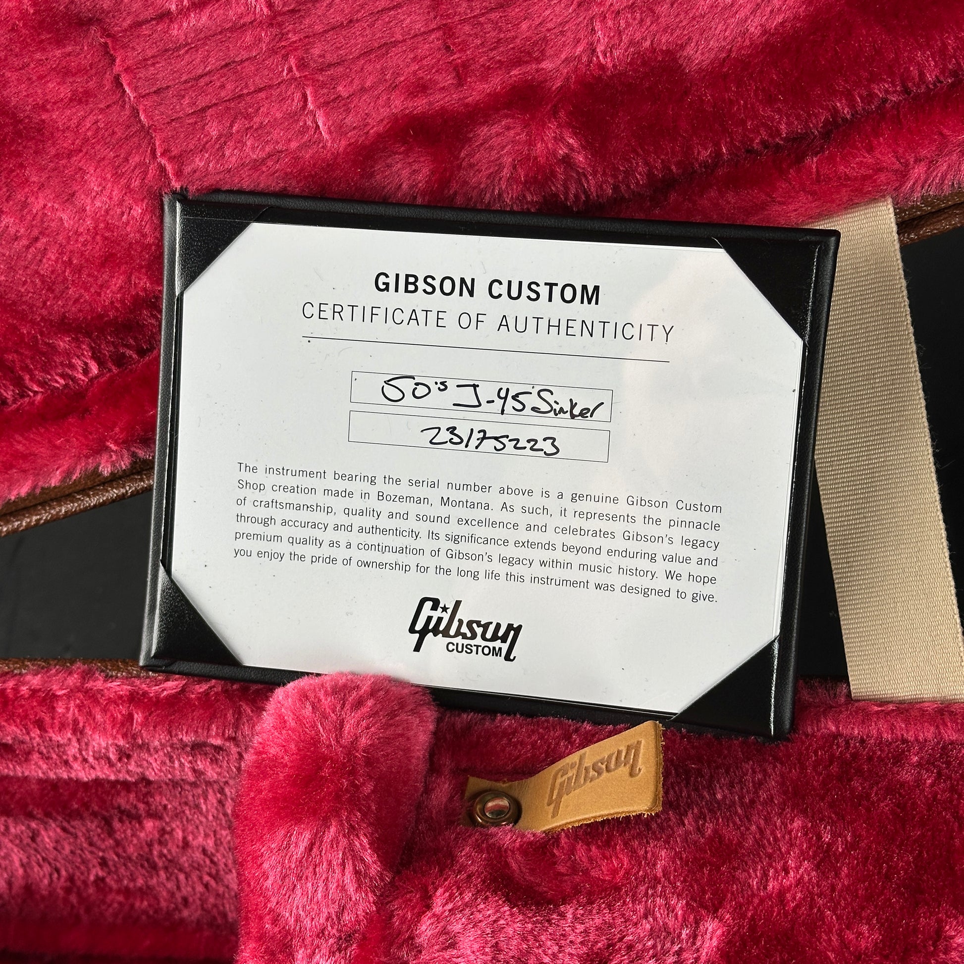 Gibson Custom Certificate of Authenticity on a red textured surface