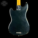 The back of a vintage-style electric guitar with a black body, a yellow maple neck, and a chrome hardware plate near the neck joint, shown against a black background.