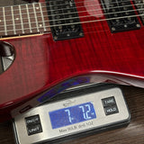 Red electric guitar on a digital scale displaying weight