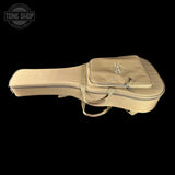 A beige guitar or ukulele hard case with a zippered headstock pocket and carrying strap, shown against a solid black background. A Tone Shop logo watermark is visible in the top-left corner.