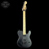 Black electric guitar with a visible brand logo on a black background