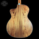 Close-up of the back of an acoustic-electric guitar showing a rich wood grain finish, with a cutaway body shape and a light blue headstock visible at the top against a black background.