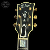 Gibson guitar headstock with brand logo on a black background