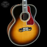 Acoustic guitar with a sunburst finish on a black background, featuring the Tone Shop logo.